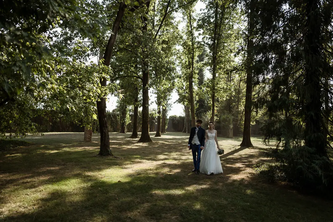 Sposi che camminano mano nella mano nel parco de La Bassanina
